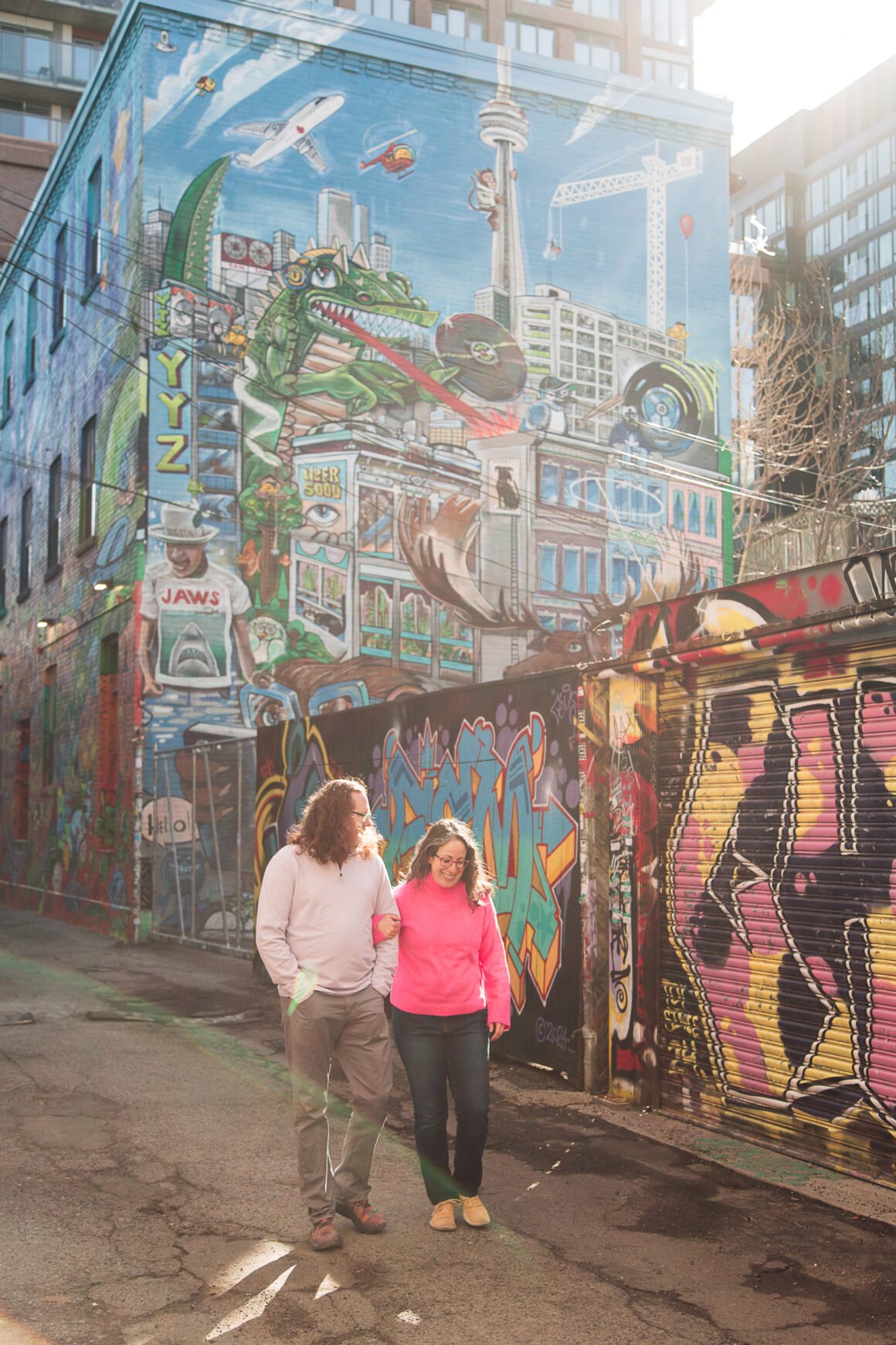 photo of Kate and her partner walking in Graffiti Alley in Toronto